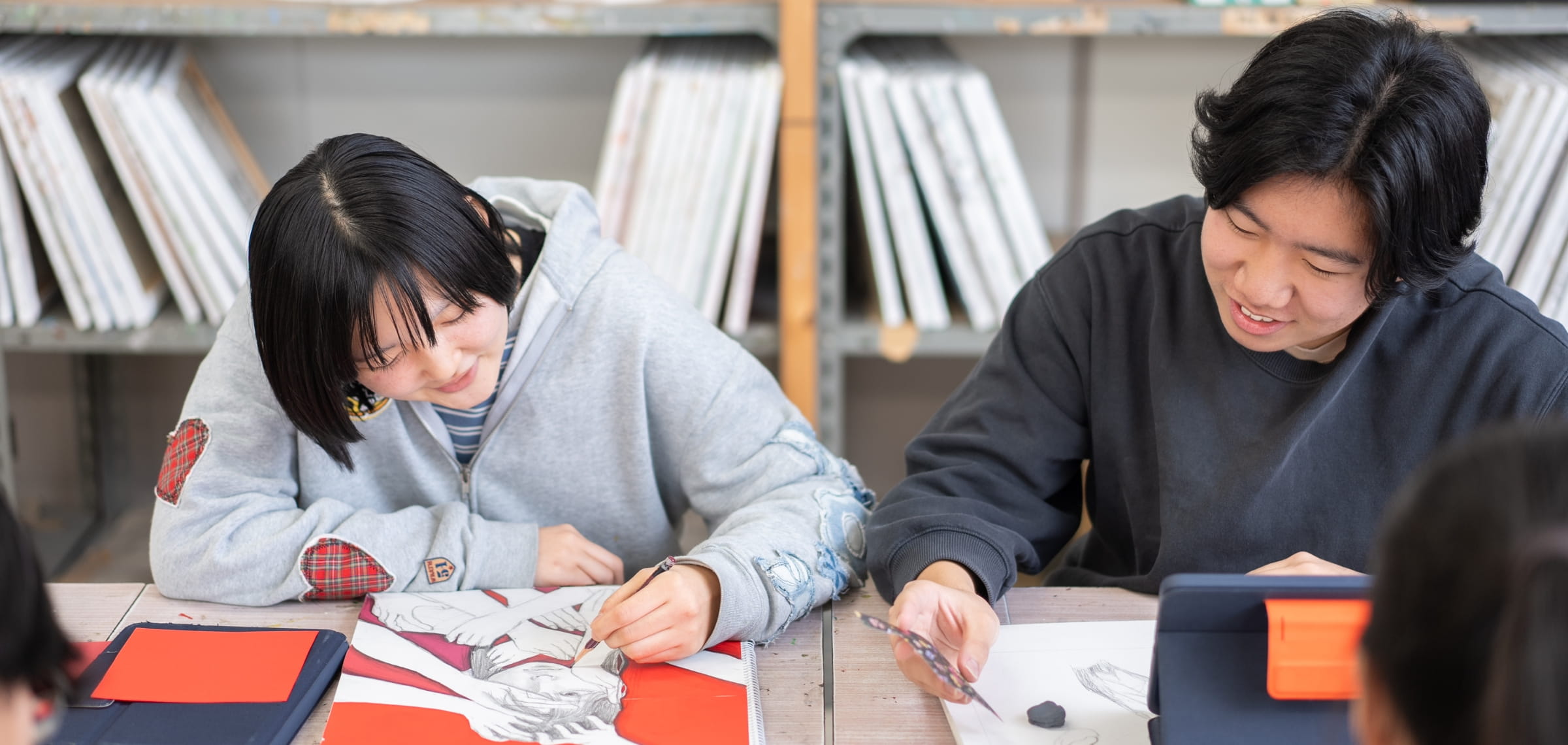 2人の学生が楽しそうに絵を描いている様子